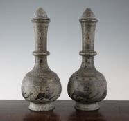 A pair of Persian Islamic carved grey stone bottle vases with lids, 13in. A pair of Persian