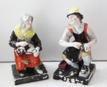 A pair of Staffordshire pottery figures, c.1820, the cobbler and his wife, with dog and cat