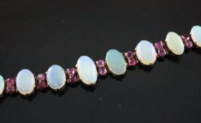 A gold white opal and ruby bracelet, 6.5in. A gold white opal and ruby bracelet, set with thirteen