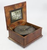 A table top polyphon, 21.5in., top a.f. A table top polyphon, in walnut case, the hinged lid painted