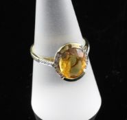 A modern 9ct gold, oval citrine and diamond set dress ring, size P. A modern 9ct gold, oval