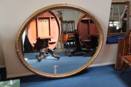 A large 19th century oval gilt and composite wall mirror A large 19th century oval gilt and