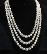 A triple strand graduated cultured pearl necklace with diamond set gold and silver starburst