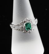 An 18ct white gold, emerald and diamond set dress ring, size O. An 18ct white gold, emerald and