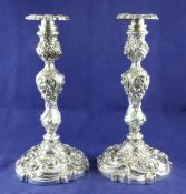 An ornate pair of Edwardian rococco style silver candlesticks, weighted. An ornate pair of Edwardian