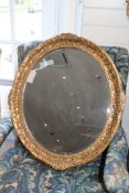 A George III style gilt and composite oval wall mirror, W.2ft 5.5in. A George III style gilt and