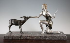 An Art Deco patinated and silvered metal figure group modelled as Diana the Huntress and a deer,