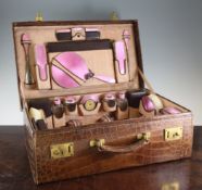 A George V silver and pink guilloche enamel mounted travelling toilet set, A George V silver and