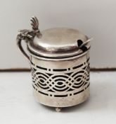 An Edwardian silver mustard pot, the pot with pierced decoration with blue glass liner and later