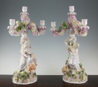 A pair of Sitzendorf figural porcelain three branch candelabra A pair of Sitzendorf figural
