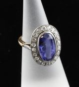 A two colour gold, synthetic sapphire and diamond set oval dress ring, size K. A two colour gold,