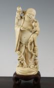 A Chinese ivory Budai A Chinese ivory standing figure of Budai, early 20th century, a smile upon his