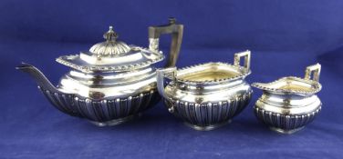 A late Victorian demi fluted silver three piece tea set, of rounded rectangular form, with