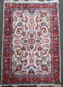 An Iranian carpet, with field of scrolling foliage and vases on an ivory ground and five row foliate