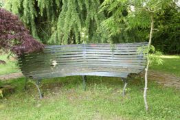 A Victorian cast iron and green painted corner garden bench, with pierced trestle end supports