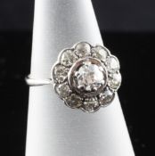 An 18ct white gold and diamond cluster ring, of flowerhead design, set with eleven stones, size K.