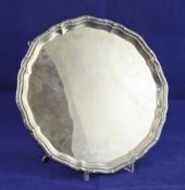 A George V silver salver, of shaped circular form, with reeded ribbon border, on hoof feet, Barker