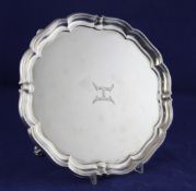 A George V silver salver, of shaped circular form, with engraved initial, on scroll feet, George