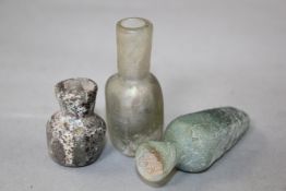 Three Roman glass miniature bottles, 2nd-4th century AD, all with mineral iridescence, 1.1-2.3in.