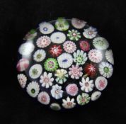 A Clichy spaced millefiori blue ground paperweight, 19th century, decorated with floret canes, 3in.