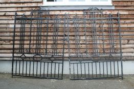 A pair of black painted wrought iron gates, with architectural scrolling crests, 4ft 4.75in.