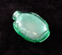 A Chinese green glass snuff bottle, 19th century, of flattened ovoid form, each side carved in