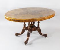 A Victorian oval burr walnut and boxwood inlaid loo table, on turned columns and carved scroll