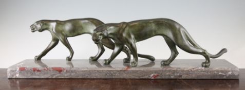 A French Art Deco patinated spelter figure group, modelled as two panthers on a grey marble