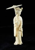 A Japanese ivory figure of a Bijin, early 20th century, holding a parasol in her right hand and a