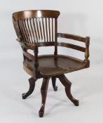 An E.W. Godwin walnut revolving tub shaped desk chair, on four shaped supports