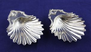 A pair of George III silver butter shells, with engraved armorial and gadrooned border, on conch