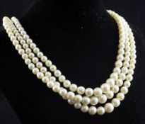 A 1920`s triple strand graduated cultured pearl necklace, with 9ct gold and heart shaped garnet