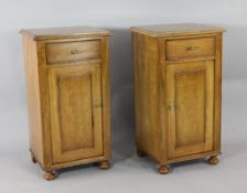 A pair of satinwood bedside cupboards, each with single drawer over single panelled door on bun