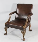 A George III style Gainsborough type open armchair, with brown leather studded upholstery, carved