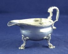 An 18th century Scottish? silver sauce boat, with gadrooned boder, on ribbed knees and paw feet,
