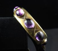 A Victorian gold and amethyst stiff bracelet, set with eight foil backed cabochon amethysts with