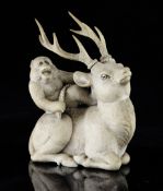 A Japanese ivory group of a monkey upon a stag, Meiji period, signed Gyokudo, the stag in