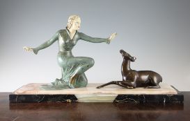 An Art Deco painted brass figure group, modelled as a crouching woman beside a deer on a rectangular