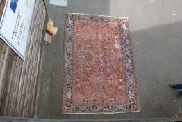 A Heriz carpet, with field of geometric foliate motifs, on a red ground, with three row border, 10ft