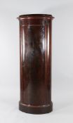 A 19th century Danish Biedermeier style mahogany oval pedestal cupboard, the single cupboard door