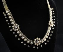 An Edwardian, gold, diamond and split pearl fringe necklace, with flowerhead motifs and fixed