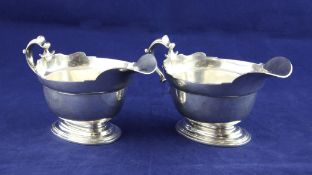 A pair of 1960`s George I style sauceboats, with cut rims and scroll handles, on oval foot, Tessiers