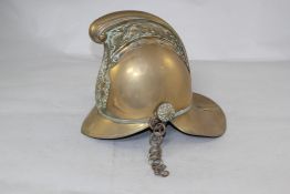 A brass Merryweather pattern fireman`s helmet, with embossed dragon crest over a front badge, 10in.