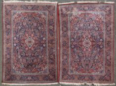 A pair of north west Persian rugs, with central diamond shaped foliate medallion, in a field of