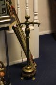 A Continental brass fire iron stand, with four hooks and shaped base on lion paw feet, 35in.