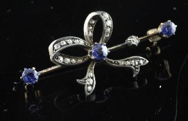 An Edwardian gold, silver, diamond and sapphire set bow bar brooch, 1.75in.