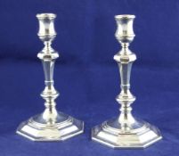 A pair of George VI 18th century style silver candlesticks, with turned panelled stems, on octagonal