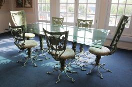 A decorative green painted metal dining suite, the table with tinted plate glass top on a pair of