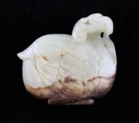 A Chinese pale celadon and brown jade figure of a crouching crane, 17th century, biting a sprig of
