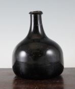A dark olive green mallet wine bottle, early 18th century, with sand disc pontil and applied